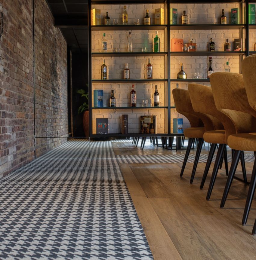 Espace bar contemporain avec mur texturé et mobilier chaleureux