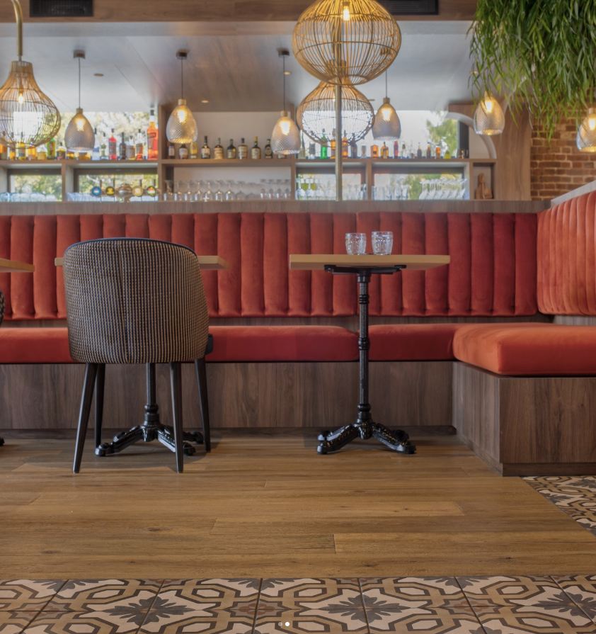 Bar de restaurant avec banquette rouge et décoration intérieure chaleureuse
